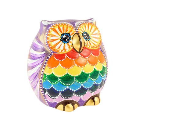 A clay figurine of an owl painted in bright colors