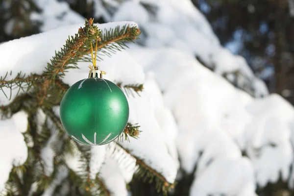 Weihnachtsspielzeug auf schneebedeckten Tannenzweigen — Stockfoto