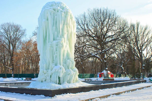 Ice fountain in the city park in the rays of the afternoon sun i — стоковое фото