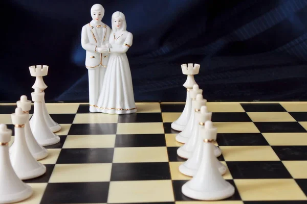 Gelin ve damat ch tarafından çevrili bir satranç tahtası üzerinde heykelcik