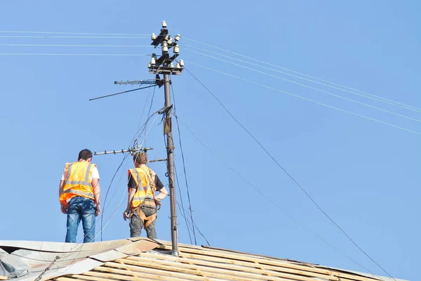 Steeplejacks on the roof of the building which is under repair — Stock Photo, Image
