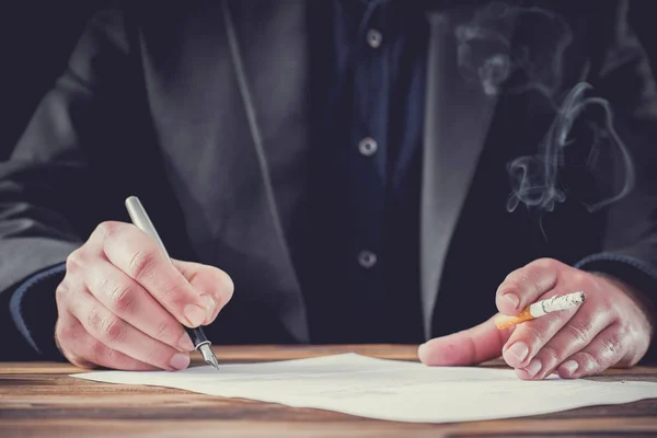 Smoking Businessman Signing Formal Letter. Stressful Atmosphere