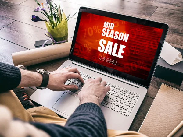 Satılık kavramı. Laptop için kullanarak adam online satış alışveriş sezonu ortalarında