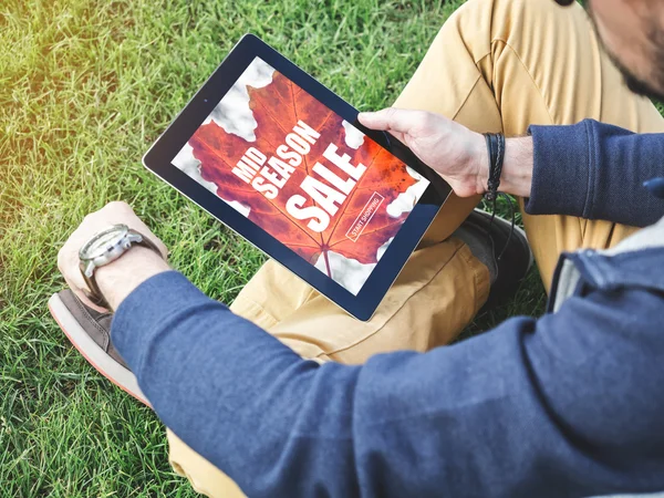 Genç adam için dijital tablet ile çalışan online alışveriş, sezon satış satış promosyon indirim kavramı orta