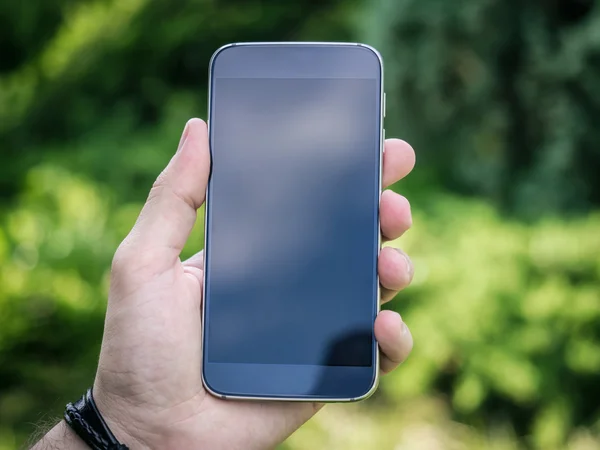 Mano del hombre sosteniendo teléfono inteligente móvil con pantalla en blanco —  Fotos de Stock