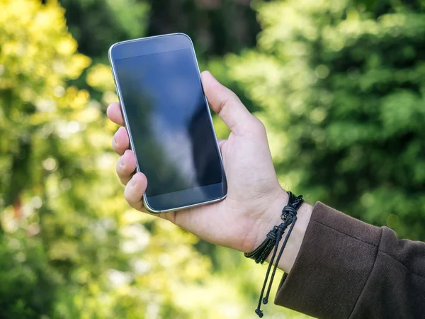 Primer plano de las manos del hombre sosteniendo y utilizando el teléfono inteligente móvil —  Fotos de Stock