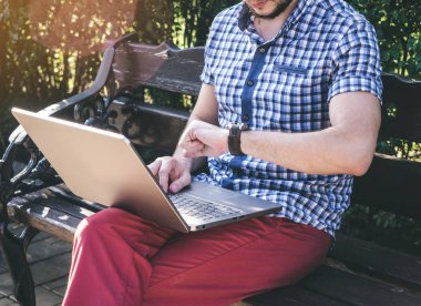 Genç gömlek giyen adam onun izlemek ve çalışma onun laptop, modern tasarım defter bakar