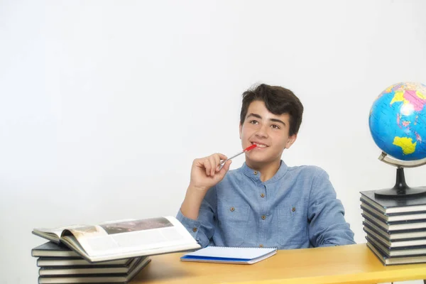 Estudante sentado em sua mesa distraído — Fotografia de Stock