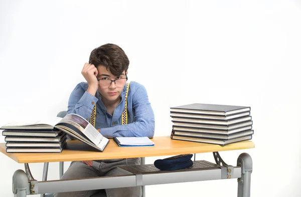 Estudante sentado em sua mesa distraído — Fotografia de Stock