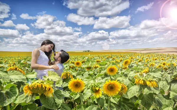 Pár milenců v poli slunečnic — Stock fotografie