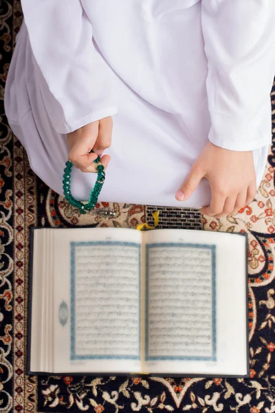 Muslim kid reading Quraan Stock Picture