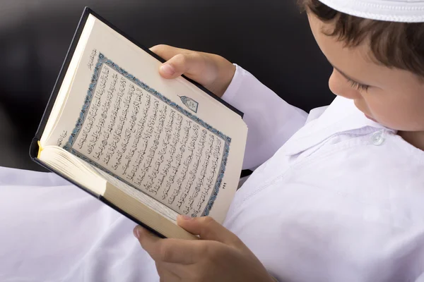 Little Muslim kid reading Quran in Ramadan Stock Image