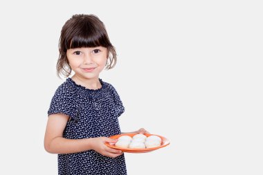 Muslim girl presenting kahk ( cookies ) in the feast clipart