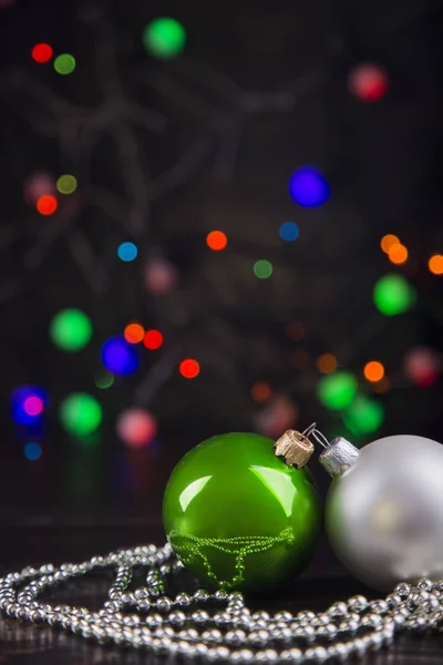 Deux boules et perles de Noël avec guirlande lumières sur bo coloré — Photo