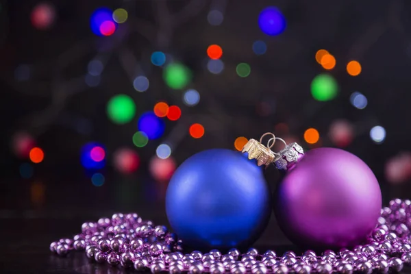 Deux boules et perles de Noël avec guirlande lumières sur bo coloré — Photo