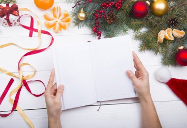 Holding eller açık defter Noel dekorasyonları zemin üzerine