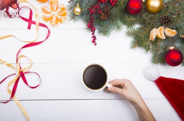 Kahve fincanı Noel süslemeleri arka planda tutan el