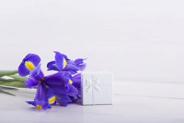 Bouquet d'iris avec coffret cadeau sur fond bois blanc — Photo