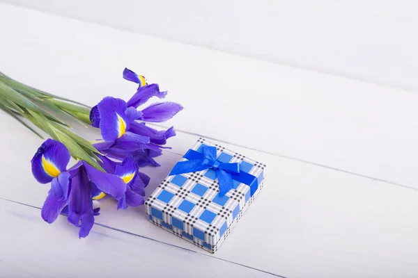 Ramo de iris con caja de regalo sobre fondo de madera blanca — Foto de Stock