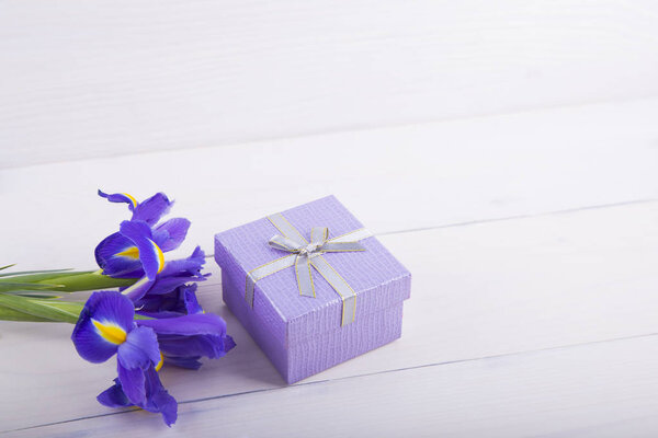 Аромат ирисов с подарочной коробкой на белом деревянном фоне
