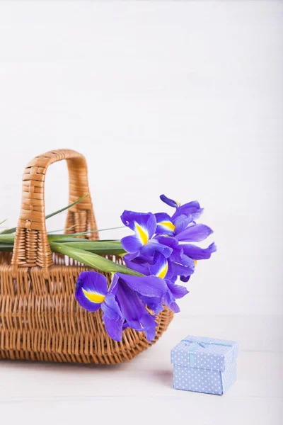Bouquet d'iris dans panier avec coffret cadeau sur fond blanc en bois — Photo