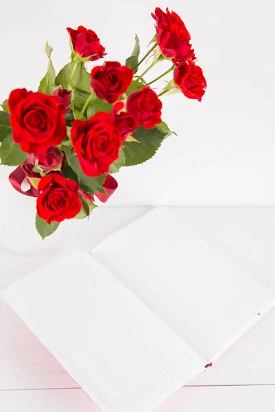 Buquê de rosas vermelhas com caderno aberto sobre fundo branco — Fotografia de Stock