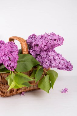 Hasır sepet beyaz arka plan üzerinde leylak buket