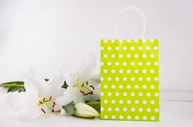 Yeşil alışveriş çantası üzerinde beyaz backgro beyaz lilyum buketi ile