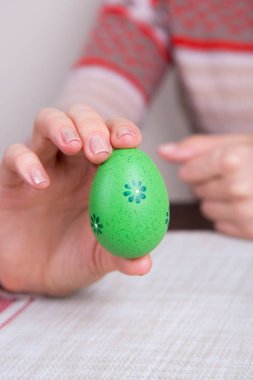 Kadın elinde yeşil renkli Paskalya yortusu yumurta