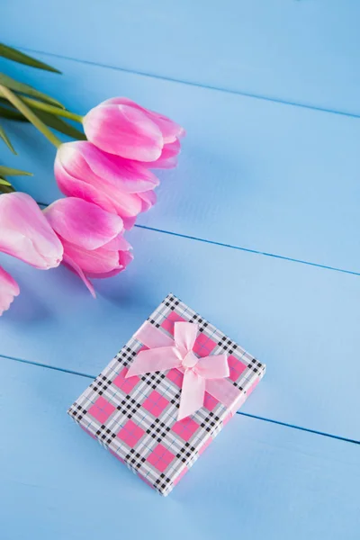 Bouquet de tulipes roses avec coffret cadeau sur fond de bois bleu — Photo