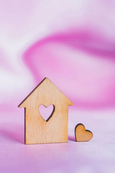 Casa de madeira com furo em forma de coração em tecido de cetim rosa — Fotografia de Stock