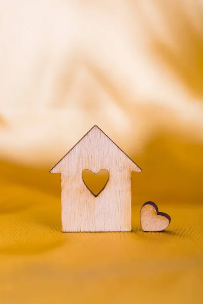 Casa de madeira com furo em forma de coração em tecido de cetim dourado — Fotografia de Stock