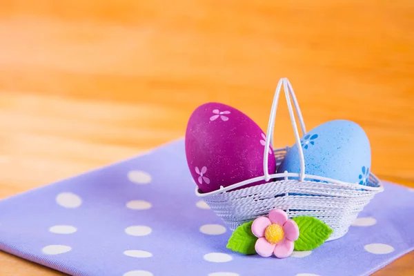 Huevos de Pascua coloridos en cesta con flor en tela en madera b — Foto de Stock