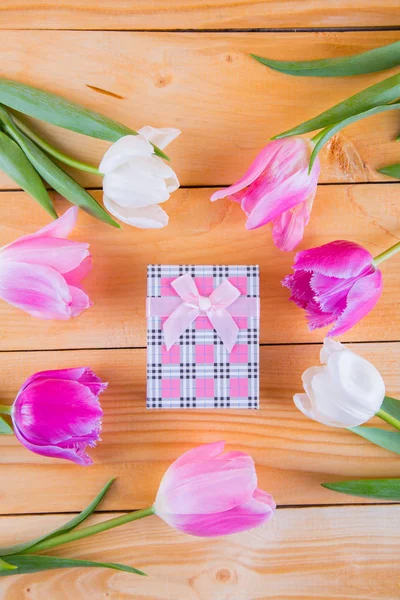 Ramo de tiernos tulipanes rosados con caja de regalo en espalda de madera clara — Foto de Stock