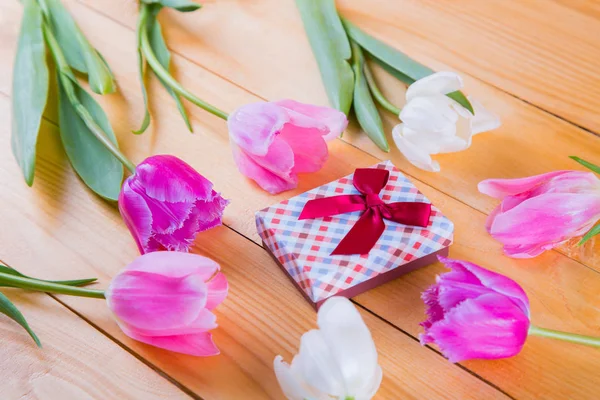 Bouquet di teneri tulipani rosa con confezione regalo su schienale in legno chiaro — Foto Stock