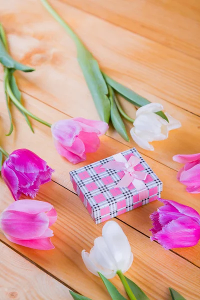 Bouquet de tulipes roses tendres avec coffret cadeau sur fond bois clair — Photo