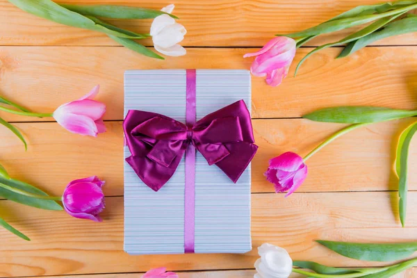 Ramo de tiernos tulipanes rosados con caja de regalo en espalda de madera clara — Foto de Stock