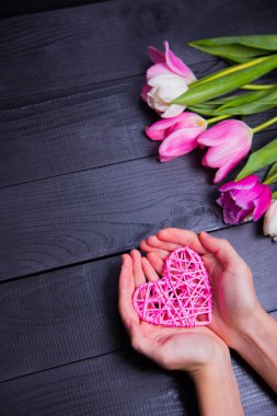 Buket ihale pembe laleler ve hasır kalp tutan elleri 