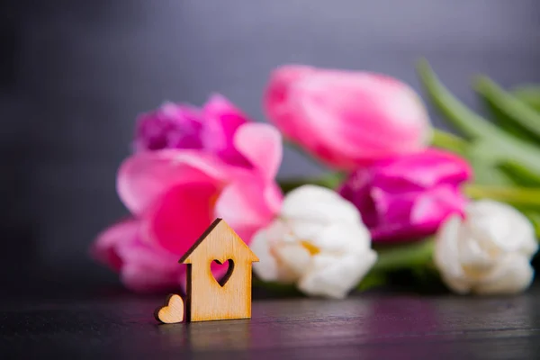 Holzhaus mit Loch in Herzform mit rosa Tulpen — Stockfoto