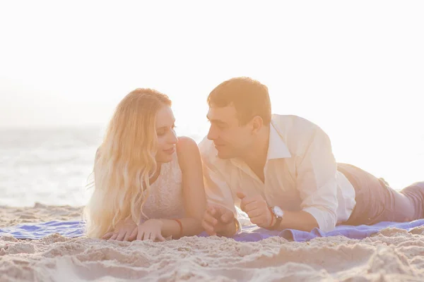 Joven pareja romántica a orillas del mar al amanecer dorado — Foto de Stock