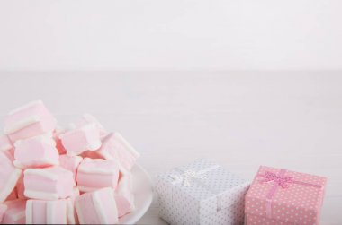 Yumuşak pembe ve beyaz marshmallow ile hediye kutuları üzerinde beyaz backgro