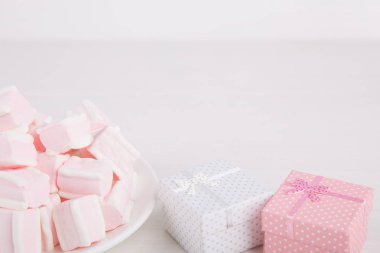 Yumuşak pembe ve beyaz marshmallow ile hediye kutuları üzerinde beyaz backgro