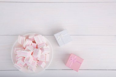 Yumuşak pembe ve beyaz marshmallow ile hediye kutuları üzerinde beyaz backgro