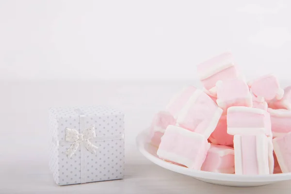 Soft pink and white marshmallow with gift box on white backgroun