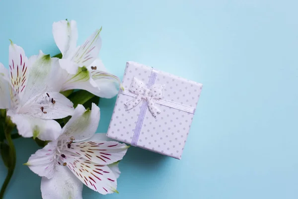 Caixa de presente branco com flores de alstroemeria no fundo azul claro — Fotografia de Stock