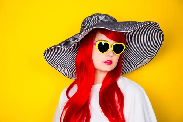 Atraktivní mladá Rudovláska v sluneční brýle a klobouk na yello — Stock fotografie