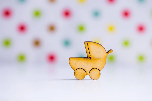 Wooden icon of baby buggy on spotted background — Stock Photo, Image