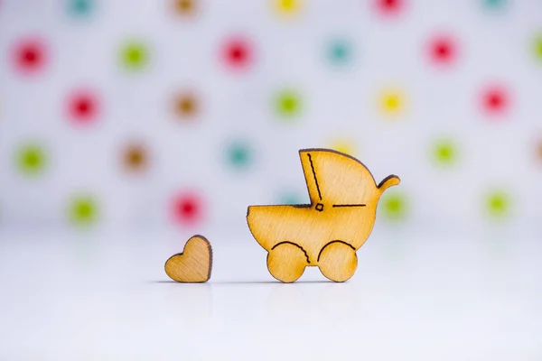 Icona in legno di baby buggy e cuoricino su sfondo maculato — Foto Stock