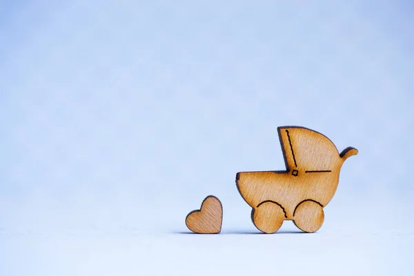 Drewniane ikony baby buggy i serduszko na szarym tle — Zdjęcie stockowe