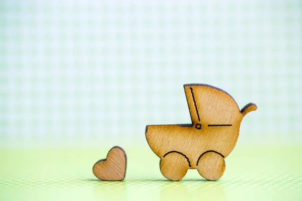 Icona in legno di baby buggy e cuoricino su ba a scacchi verde — Foto Stock